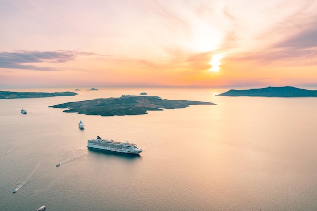 Stadt Fira, mit Blick auf Caldera, Vulkan und Kreuzfahrtschiffe, Santorini, Griechenland. Bewölkter dramatischer Himmel