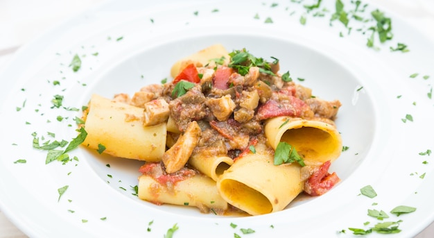 Stadt Otranto, Region Apulien, Süditalien. Traditionelle Paccheri-Nudeln mit Schwertfisch, serviert mit Tomaten, Petersilie, Olivenöl. Tageslicht, echtes Restaurant in Otranto.