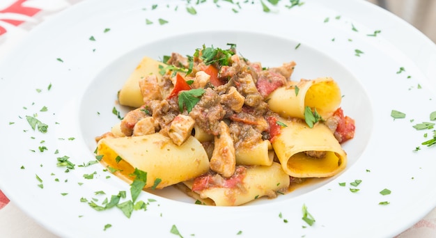 Stadt Otranto, Region Apulien, Süditalien. Traditionelle Paccheri-Nudeln mit Schwertfisch, serviert mit Tomaten, Petersilie, Olivenöl. Tageslicht, echtes Restaurant in Otranto.