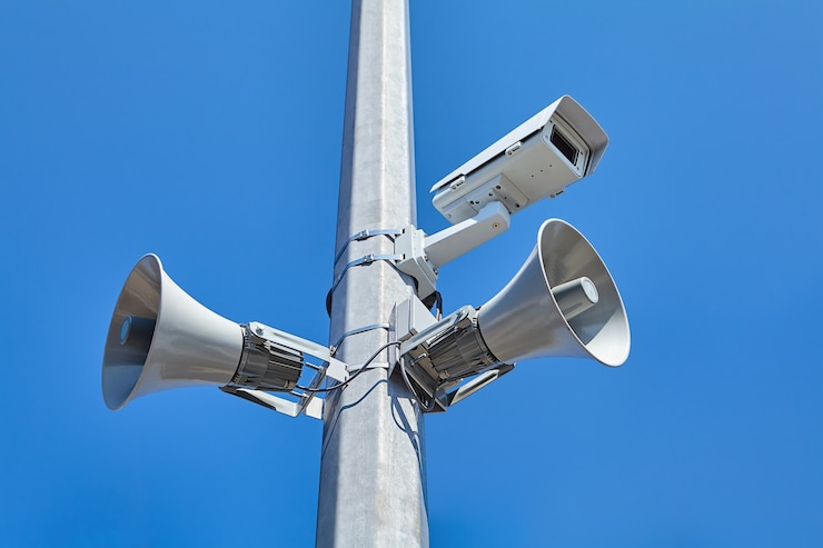 Foto stadt- und straßenvideoüberwachungssystem sowie öffentliche lautsprecher auf stahlstange montiert.