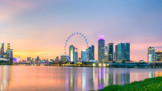 Stadt von Singapur mit der modernen Turmgebäudebeleuchtung auf der Dämmerung bunt im Wasserfluß