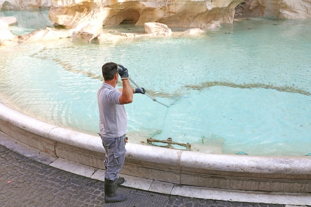 Stadtarbeiter, der Geld vom Trevi-Brunnen sammelt