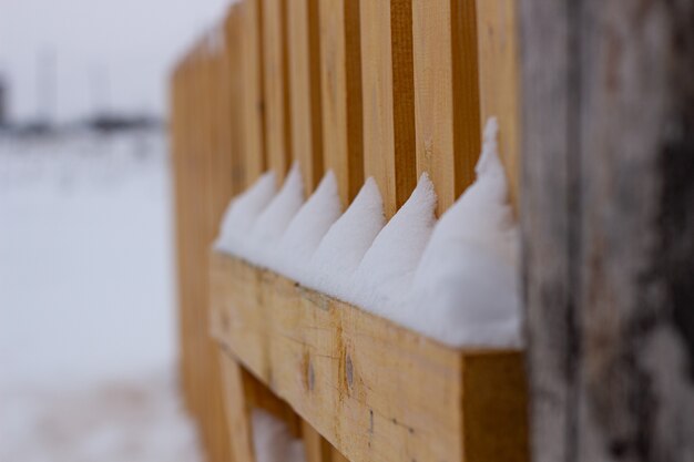 Stadtdienst säubert Schneewinter mit Schaufel nach Schneesturmhof. Sonnenlicht.