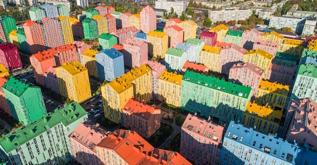 Stadtlandschaft mit bunten Gebäuden. Luftaufnahme der bunten Gebäude in der europäischen Stadt im Morgensonnenlicht. Stadtbild mit bunten Häusern, Autos auf der Straße in Kiew, Ukraine