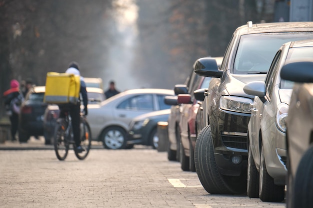 Stadtverkehr mit geparkten Autos auf der Straßenseite.