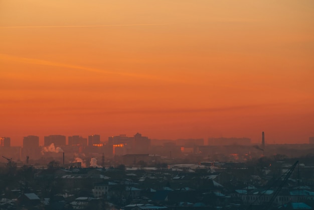 Städtische Hochhäuser hinter Privathäusern bei Sonnenuntergang.