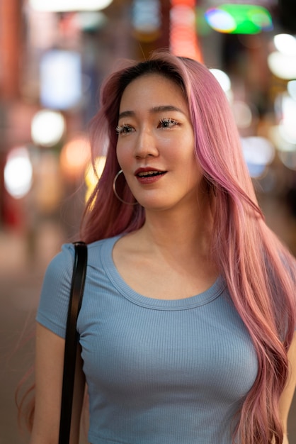 Foto städtisches porträt der jungen frau mit langen rosa haaren