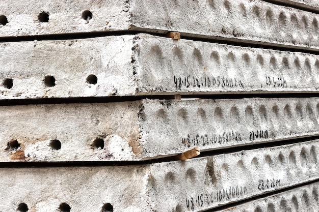 Stahlbeton-Bodenplatten werden auf der Baustelle gelagert Nahaufnahme Baukonstruktionen und Materialien aus Stahlbeton