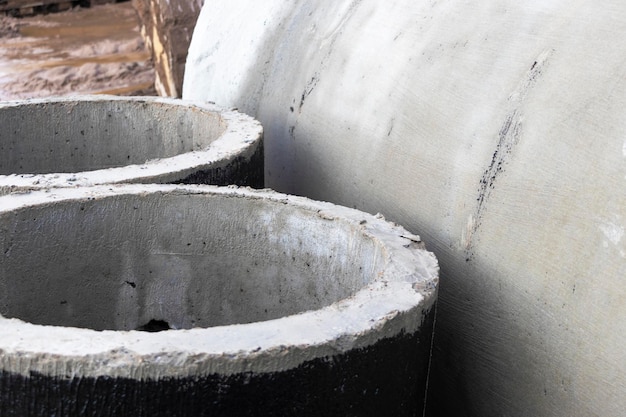 Stahlbeton-Sturmabwasserrohre, die auf einer Baustelle gestapelt sind Rohre mit großem Durchmesser Kanalisation und Wasserversorgung in einer modernen Stadt