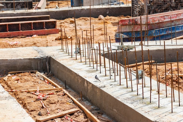 Stahlbetonfundament eines modernen monolithischen Wohngebäudes Vorbereitete Schalung mit Bewehrungsnetz zum Gießen von Beton Schmutz und Ton auf der Baustelle