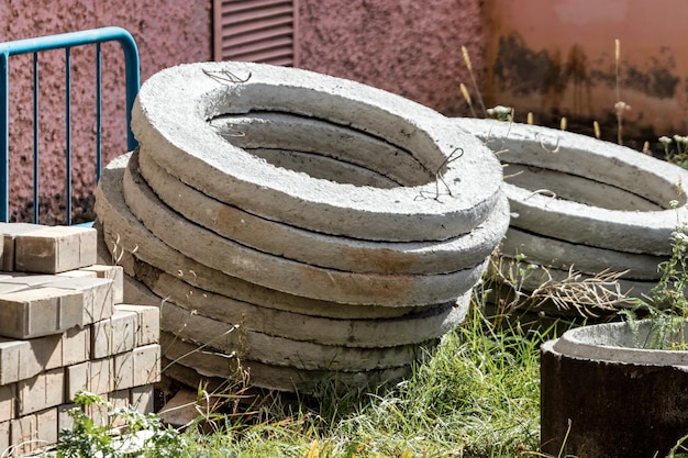 Stahlbetonringe für die Installation von unterirdischen Brunnen auf der Baustelle Stahlbetonprodukte für die Einrichtung der unterirdischen Kommunikation Kanalisation und Sanitär