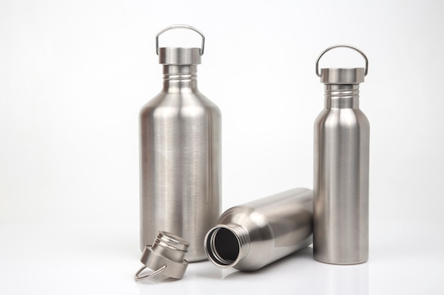 Stahlflaschen für Wasser und Getränke auf weißem Hintergrund. Überlebens-Wanderausrüstung