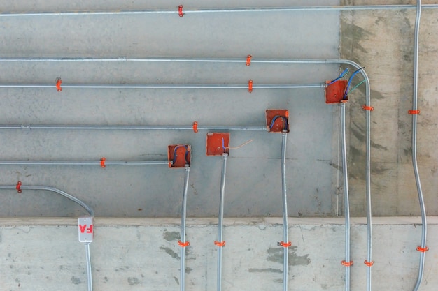 Stahlrohre für die Installation des elektrischen Verteilungssystems an der Decke im Neubau