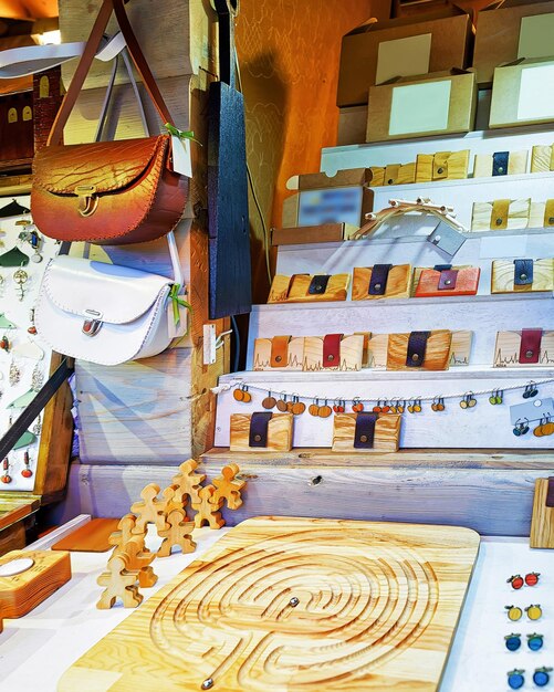 Stall mit Souvenirs aus Holz und Leder auf dem Weihnachtsmarkt in Riga in Lettland. Der Markt ist voll von verschiedenen traditionellen Waren und Souvenirs. Selektiver Fokus