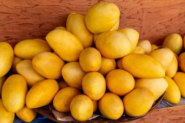 Stand del festival del mango con frutas frescas de mango amarillo en el mercado de la calle