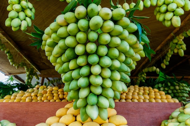 Stand del festival del mango con frutas frescas de mango amarillo en el mercado de la calle