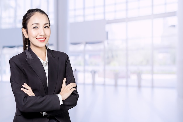 stand de mujer de negocios asiáticos con concepto de perfil de fondo de oficina blur