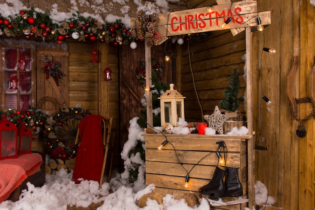 Stand de Navidad de madera iluminada dentro de una casa con diversas decoraciones navideñas.