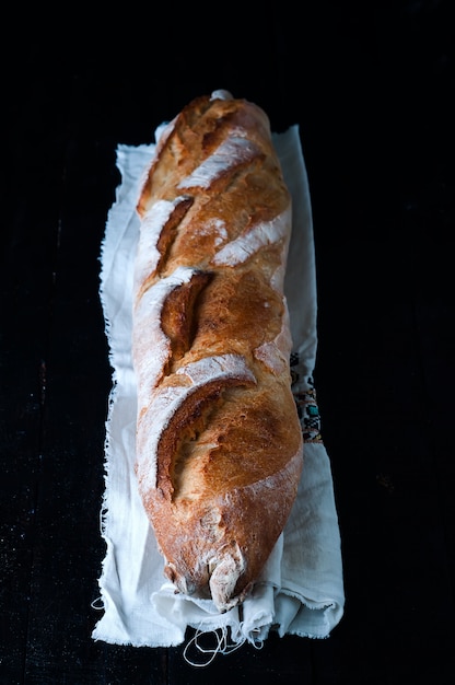 Stangenbrot auf schwarzem Hintergrund.