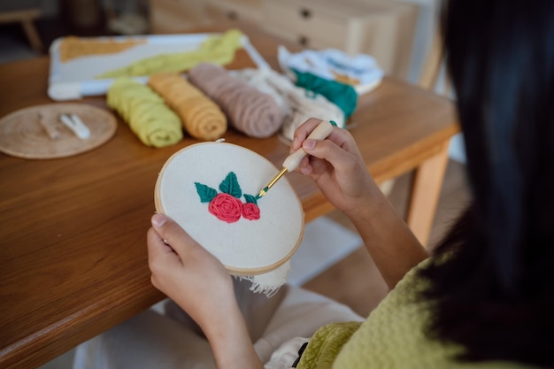 Stanznadel Asiatische Frau, die handgefertigtes Hobbystricken im Studio-Workshop-Designer-Arbeitsplatz herstellt Handgemachtes Handwerksprojekt DIY-Stickkonzept