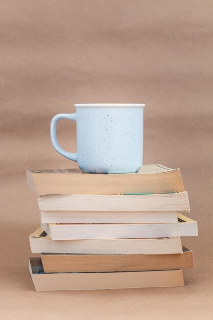 Stapel altes Buch mit einer Tasse Kaffee oder Tee beige Hintergrund