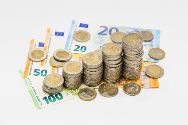 Foto stapel aufsteigender euro-münzen auf euro-banknoten. bank- und sparkonzept finanzieren