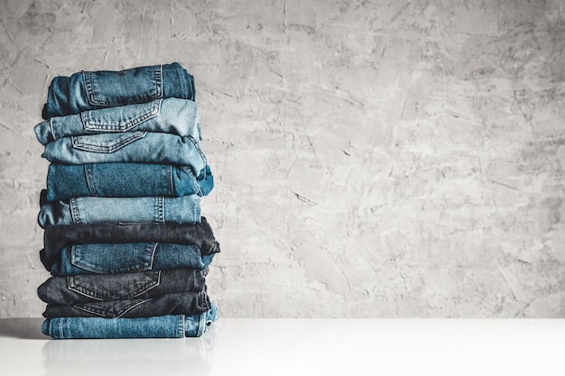 Foto stapel blue jeans auf grauem hintergrund