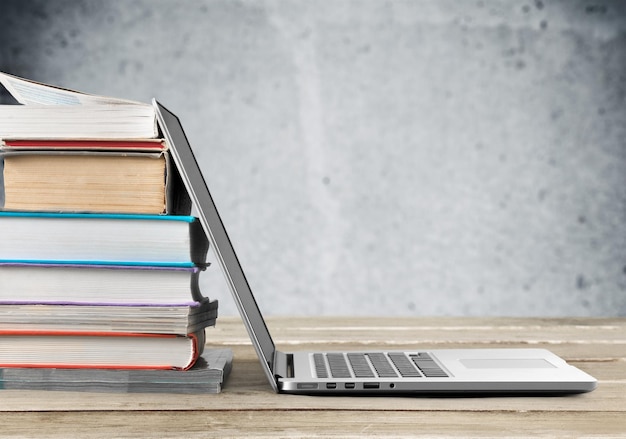 Stapel Bücher mit Laptop auf dem Tisch