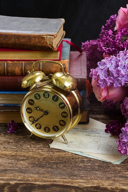 Stapel Bücher mit Uhr und Blumen