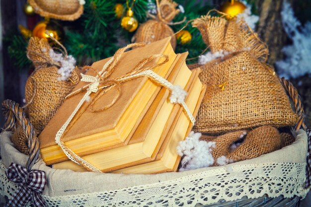 Stapel Bücher und andere Geschenke im Korb. Weihnachtsdekoration