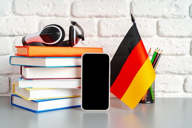 Stapel Bücher und deutsche Flagge auf dem Schreibtisch