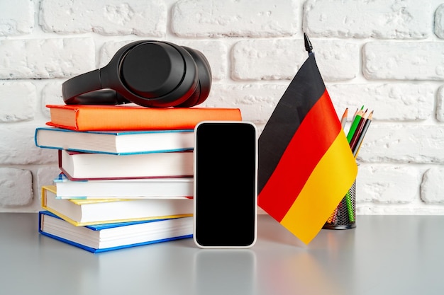 Stapel Bücher und deutsche Flagge auf dem Schreibtisch