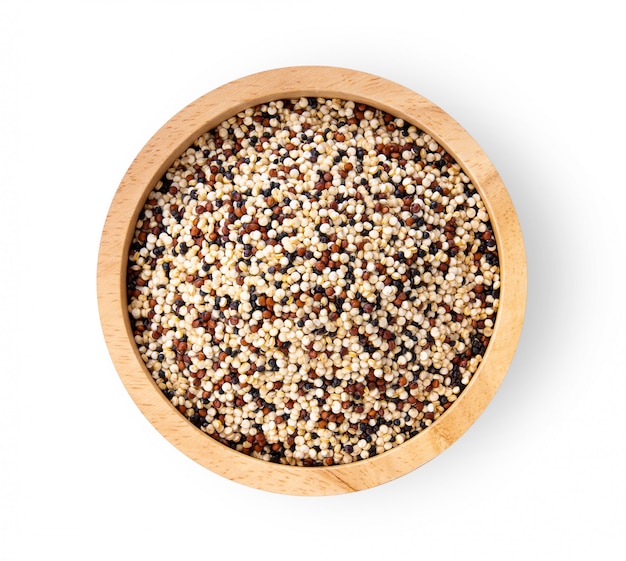 Stapel der gemischten rohen Quinoa in der Holzschale auf weißem Tisch.