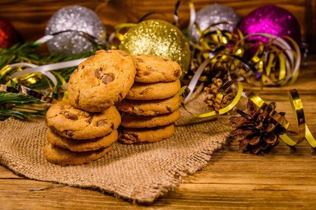 Stapel der Schokoladenkekse auf Sackleinen vor Weihnachtsdekoration