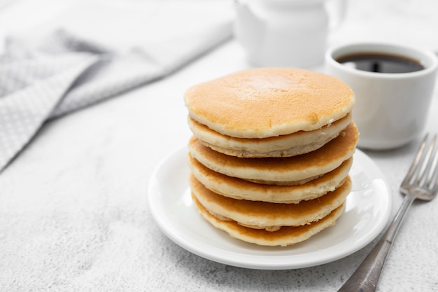 Stapel des amerikanischen clasic pfannkuchenfrühstücks oder -imbisses, getrennt auf weiß