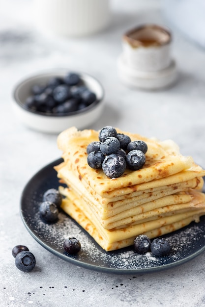 Stapel dünner Pfannkuchen, Crepes mit Blaubeeren und Puderzucker