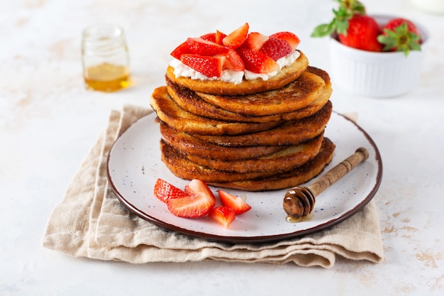 Stapel French Toast mit Hüttenkäse, Honig und Erdbeeren zum Frühstück. Selektiver Fokus