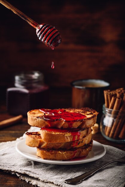 Stapel French Toasts mit Beerensirup auf weißem Teller