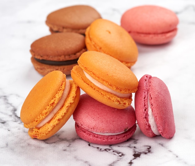 Foto stapel gebackener macarons auf einem weißen tisch in der nähe