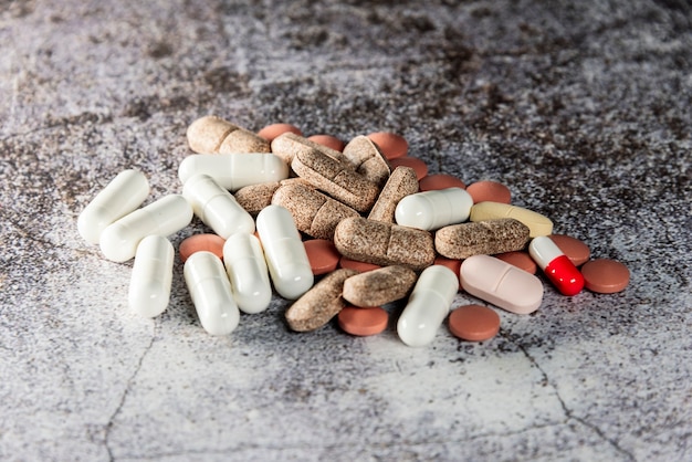 Stapel gemischter Pillen und Tabletten im Vordergrund