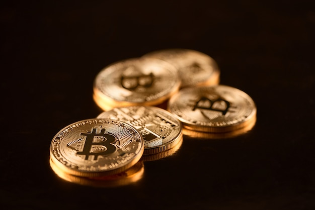 Stapel goldene Bitcoins als Welthauptkryptowährung lokalisiert auf schwarzem Hintergrund.