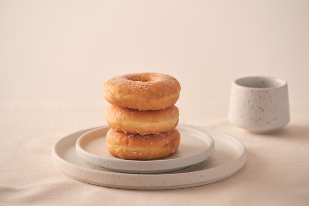 Stapel hausgemachter gebackener Donuts, die auf weißem Teller sitzen