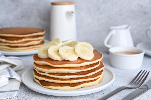 Stapel Honig- und Bananenpfannkuchen auf dem Küchentisch zum Frühstück