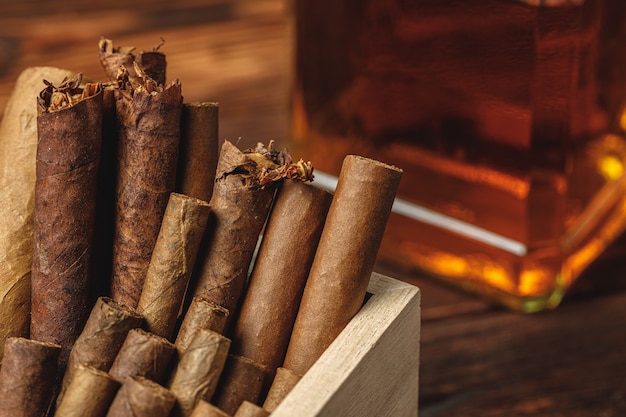 Stapel neuer kubanischer Zigarren nahe Flasche des Alkohols