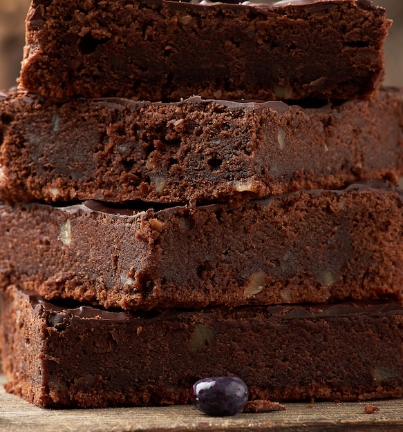 Stapel Quadrat gebackene Scheiben des Schokoladenkuchenschokoladenkuchens mit Walnüssen