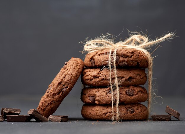 Stapel runder Schokoladenkekse, die mit einem Seil auf einer schwarzen Tafel gebunden sind