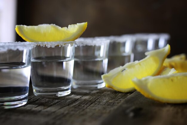 Stapel Tequila mit Salz und Zitrone auf Holzhintergrund