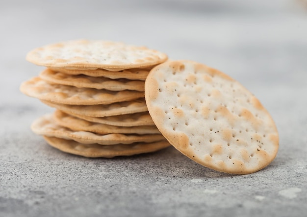 Stapel verschiedener knuspriger Bio-Maiscracker mit Sesam und Salz auf hellem Hintergrund