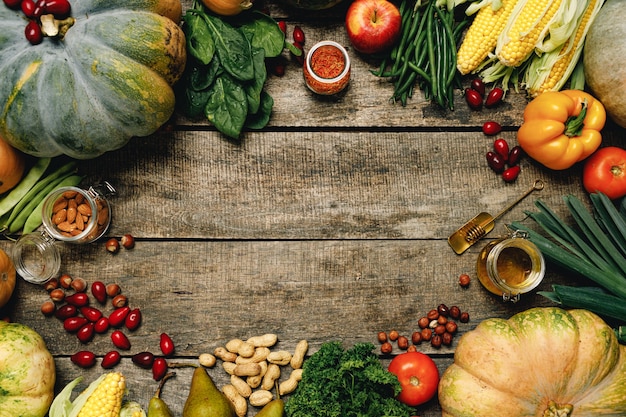 Stapel von buntem Obst und Gemüse auf Holzoberfläche