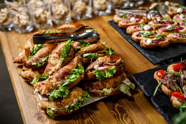 Stapel von Croissant-Sandwich auf einem Holztisch.